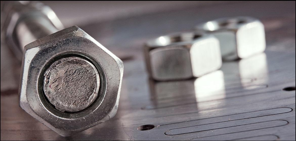 Close-up of a heavy hex bolt end with hex nuts